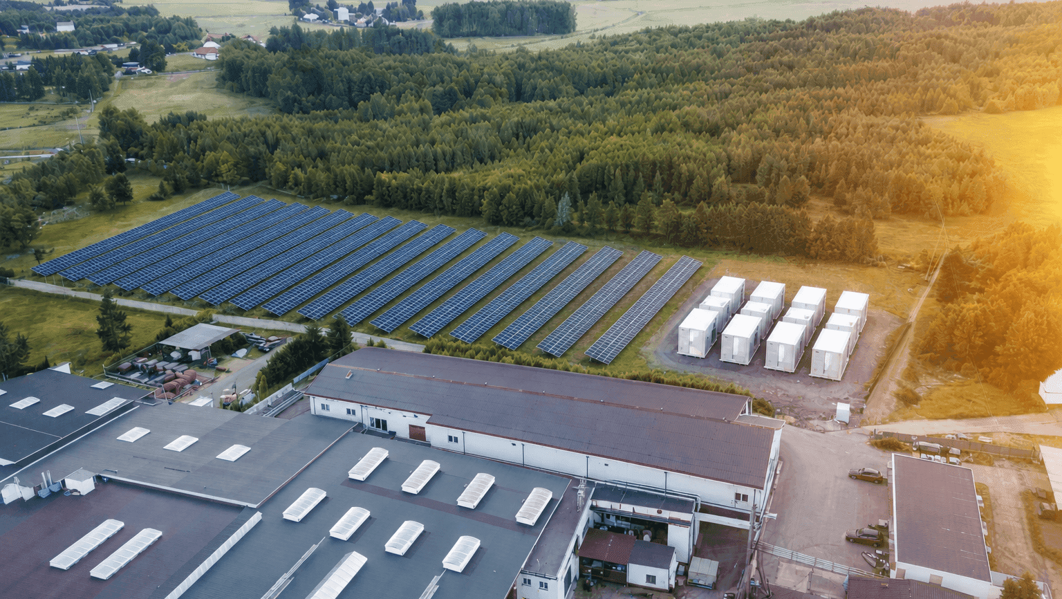 Solar array and battery energy storage units beside an industrial facility